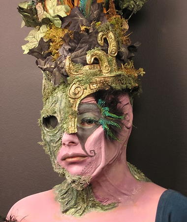 Students painting detailed creature masks under Rob Burman's supervision